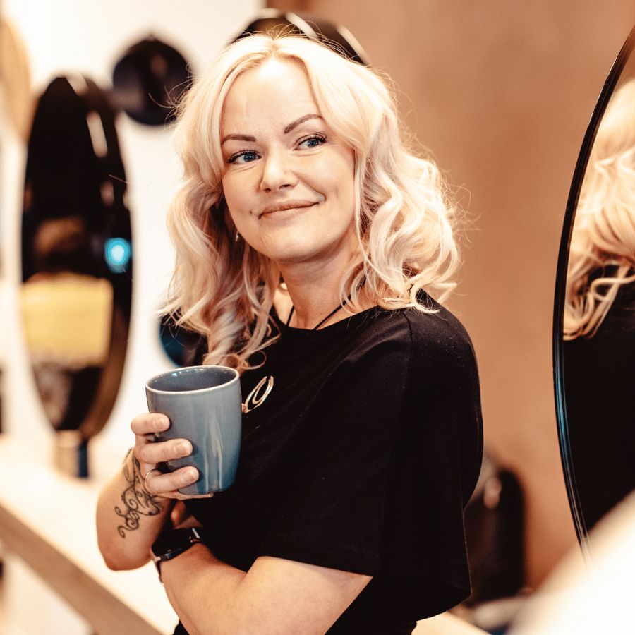 Frisør tar en kaffepause ved speilene